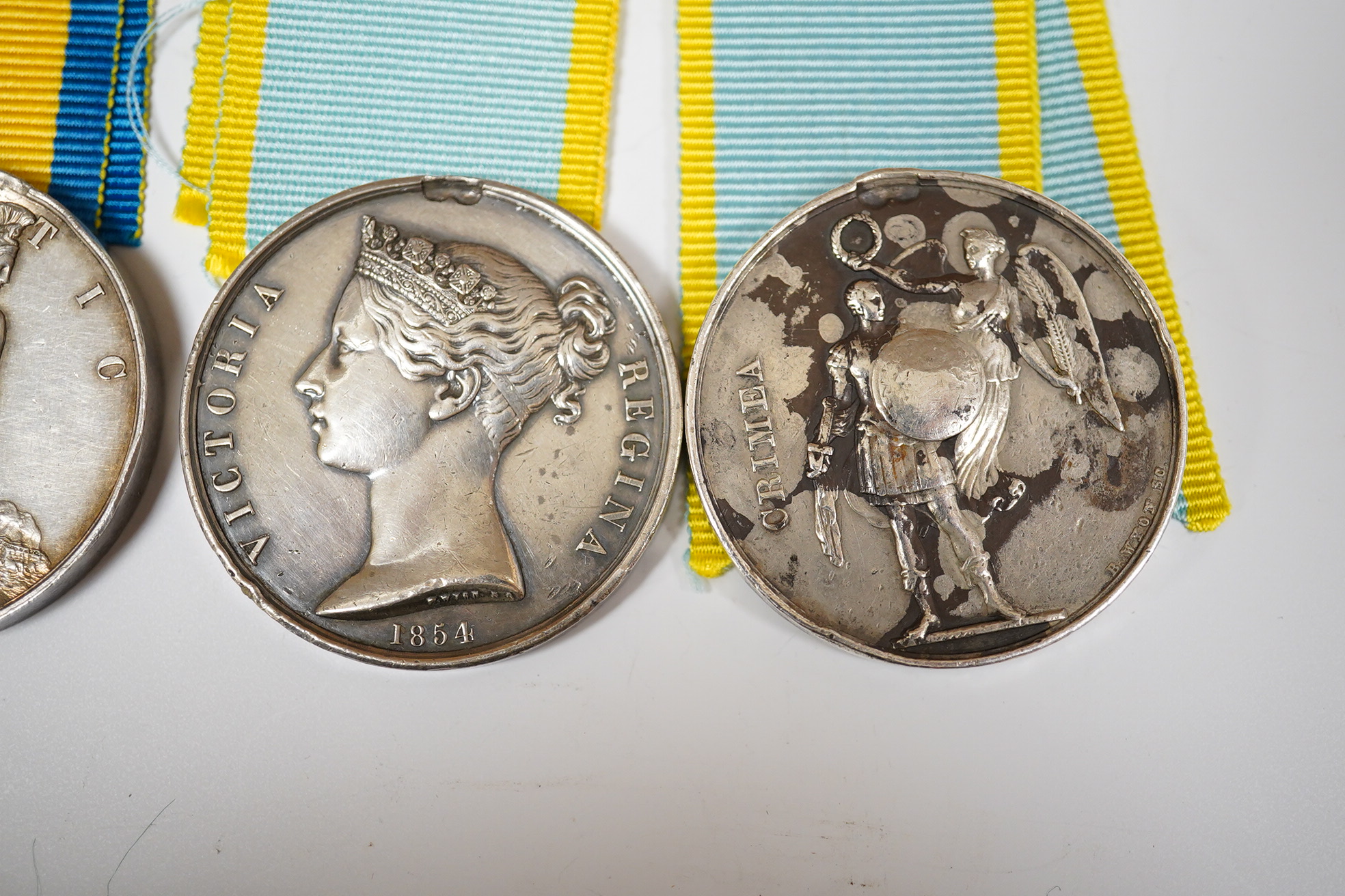 Two Crimea medals, a Baltic medal, all disc only and unnamed with a replica Turkish Crimea medal, unnamed, (3).